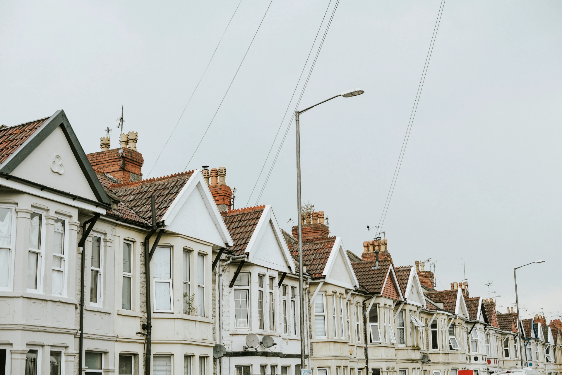Row of terraced houses with repeated brick chimney stacks along the roof line